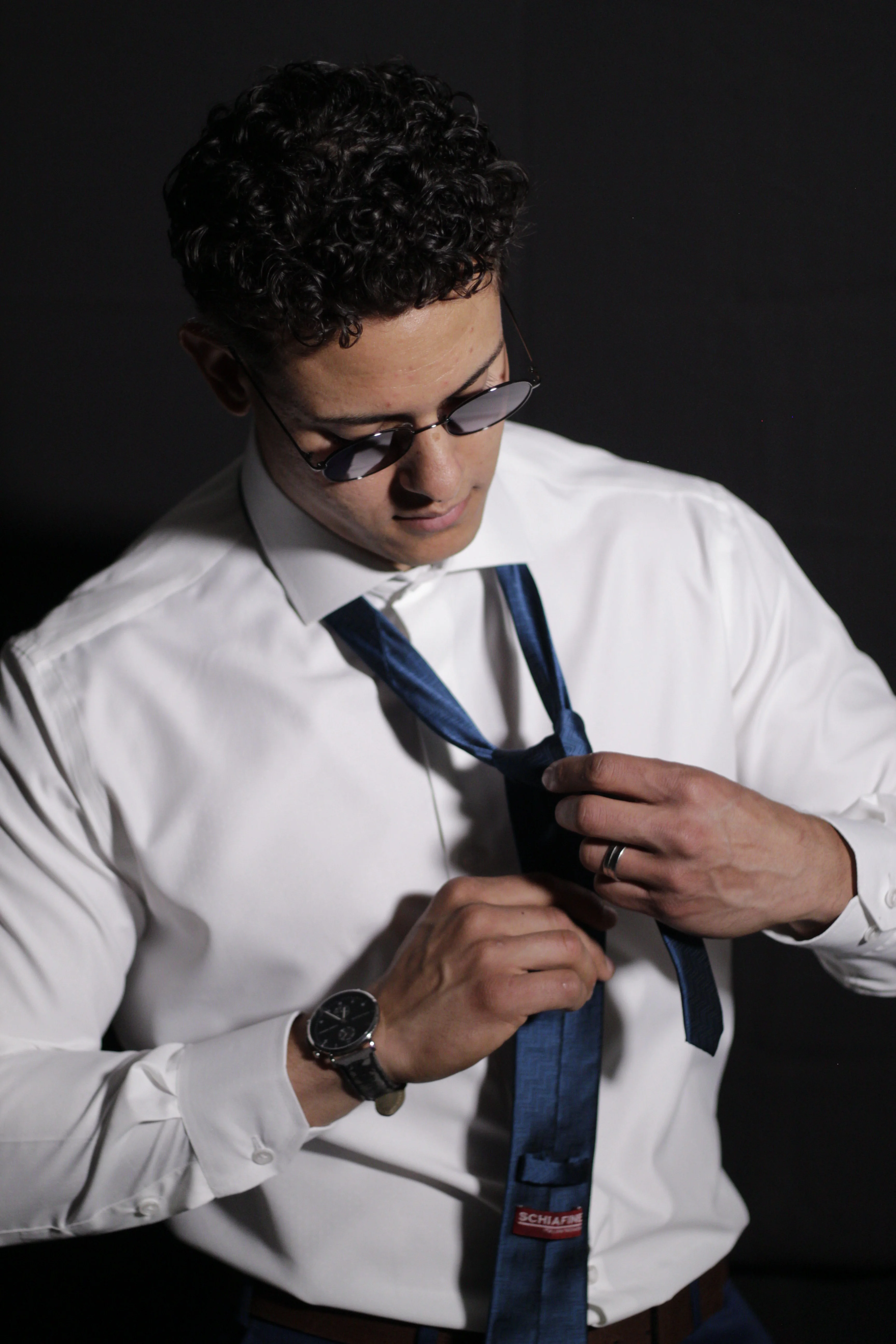 Homem ajustando gravata em composição social para formaturas e eventos.